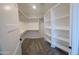 Walk-in closet featuring custom shelves, and carpeted floors for storage and organization at 11142 E Copper Dust Trl, Florence, AZ 85132