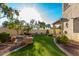 Landscaped backyard featuring synthetic grass, stone borders, and a built-in fire pit area at 11713 W Tonto St, Avondale, AZ 85323