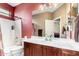 Bathroom features a red accent wall, white countertops, and a shower-tub combination at 11713 W Tonto St, Avondale, AZ 85323