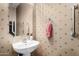 Bathroom with pedestal sink, decorative wallpaper and convenient grab bar at 11713 W Tonto St, Avondale, AZ 85323