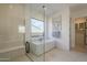 Elegant bathroom featuring a glass shower, soaking tub with stylish black fixtures, and minimalist decor at 12328 E Black Rock Rd, Scottsdale, AZ 85255