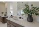 Modern bathroom with white countertops, undermount sink, and a decorative plant in a black vase at 12328 E Black Rock Rd, Scottsdale, AZ 85255