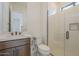 Modern bathroom featuring sleek vanity, toilet, and glass-enclosed shower with stylish tile surround and window at 12328 E Black Rock Rd, Scottsdale, AZ 85255