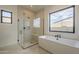 Bright bathroom with a modern glass shower, soaking tub, and two large windows at 12328 E Black Rock Rd, Scottsdale, AZ 85255