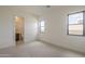 Bright, unfurnished bedroom with neutral carpet, multiple windows, and an ensuite bathroom at 12328 E Black Rock Rd, Scottsdale, AZ 85255
