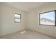 Bright bedroom with two large windows offering stunning views, complemented by neutral walls and tile flooring at 12328 E Black Rock Rd, Scottsdale, AZ 85255