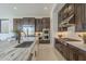 Open kitchen with a large island, stainless steel appliances, dark wood cabinetry, and modern fixtures at 12328 E Black Rock Rd, Scottsdale, AZ 85255