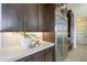 Kitchen displaying stainless steel appliances and dark wood cabinetry, complemented by bright lighting and a view to a walk-in pantry at 12328 E Black Rock Rd, Scottsdale, AZ 85255
