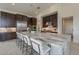 Spacious kitchen with a large island, seating, stainless steel appliances, and stylish dark wood cabinetry at 12328 E Black Rock Rd, Scottsdale, AZ 85255