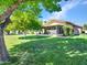 Beautiful backyard with a screened-in patio, complemented by green lawn and mature shade trees at 12519 W Castle Rock Dr, Sun City West, AZ 85375
