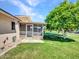 Exterior view of home with a screened-in patio and lush lawn at 12519 W Castle Rock Dr, Sun City West, AZ 85375