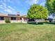 Backyard of home featuring a large tree, screened-in patio, and solar panels at 12519 W Castle Rock Dr, Sun City West, AZ 85375