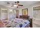 This bedroom features a ceiling fan, tiled floors, large mirror, and adjacent bathroom and closet at 12519 W Castle Rock Dr, Sun City West, AZ 85375