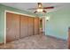 Bedroom includes ceiling fan, closet with sliding wood doors and tiled floors at 12519 W Castle Rock Dr, Sun City West, AZ 85375