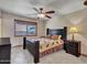 Comfortable bedroom features a ceiling fan, tiled floor and window with privacy blind at 12519 W Castle Rock Dr, Sun City West, AZ 85375