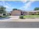 Charming single-story home featuring a well-manicured front yard and attached two-car garage at 12519 W Castle Rock Dr, Sun City West, AZ 85375