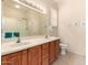 Well-lit bathroom showcases double sinks, wood cabinets, a large mirror, and a convenient walk-in shower at 15074 W Cactus Ridge Way, Surprise, AZ 85374