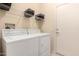 Functional laundry area with a washer, dryer, and wire shelving for organized storage solutions at 15074 W Cactus Ridge Way, Surprise, AZ 85374