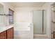 Bright bathroom featuring a large tub, walk-in shower, and stylish vanity with double sinks at 15123 W Custer Ln, Surprise, AZ 85379