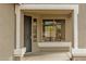 Covered front porch featuring a security door, sidelight window, and textured columns offering a welcoming entrance at 15123 W Custer Ln, Surprise, AZ 85379