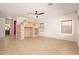 Bright living room with neutral walls, a ceiling fan, built-in shelving, and tiled flooring providing a comfortable living space at 15123 W Custer Ln, Surprise, AZ 85379