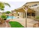 Backyard view showcasing a private pool, rock waterfall, and outdoor patio space under a pergola at 15123 W Custer Ln, Surprise, AZ 85379