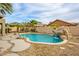 Backyard view showcasing a private pool, rock waterfall, with lush desert landscaping at 15123 W Custer Ln, Surprise, AZ 85379