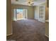 Spacious living room featuring modern ceiling fan, built-in shelving and sliding glass door to patio at 16013 S Desert Foothills Pkwy # 1050, Phoenix, AZ 85048