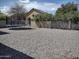 Gravel backyard featuring a trampoline, block wall, and trees at 1875 N St Francis Pl, Casa Grande, AZ 85122