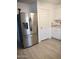 Stainless steel refrigerator in kitchen with matching white cabinets and light wood-look flooring at 1875 N St Francis Pl, Casa Grande, AZ 85122
