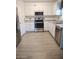 Well-lit kitchen features white cabinets, stainless steel appliances, and light wood-look flooring at 1875 N St Francis Pl, Casa Grande, AZ 85122