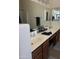 Bathroom vanity featuring a large mirror, double sinks and wood cabinets at 19427 N Toya St, Maricopa, AZ 85138