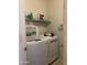 Functional laundry room with front loading washer and dryer, and wire shelving for storage solutions at 19427 N Toya St, Maricopa, AZ 85138