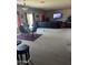 Large living room with black sofa, carpeted floors and big-screen television with a view to the patio at 19427 N Toya St, Maricopa, AZ 85138