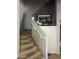 Carpeted staircase leading to the upper level, accented with neutral decor and art at 19427 N Toya St, Maricopa, AZ 85138