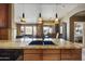 Granite island kitchen features modern lighting, wood cabinetry, and open access to living and bedroom areas at 19475 N Grayhawk Dr # 2132, Scottsdale, AZ 85255