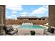 Covered patio overlooking a pool, waterfall feature, and desert landscaping at 23434 N 76Th Way, Scottsdale, AZ 85255