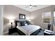 Cozy bedroom with a ceiling fan, a large window, dark-colored furniture, and soft carpeting at 23434 N 76Th Way, Scottsdale, AZ 85255