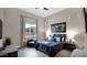 Comfortable bedroom with a large window, a blue accent chair, and a stylish upholstered bed at 23434 N 76Th Way, Scottsdale, AZ 85255