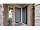 Inviting front entryway featuring dual doors, stylish stone accents, and lush green plants at 23434 N 76Th Way, Scottsdale, AZ 85255