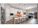 Bright kitchen featuring white cabinets, granite countertops, a large island with seating, and modern pendant lighting at 23434 N 76Th Way, Scottsdale, AZ 85255