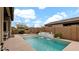 Backyard pool featuring a rock waterfall, outdoor furniture, and desert landscaping at 23434 N 76Th Way, Scottsdale, AZ 85255
