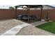 Cozy backyard seating area with a charming patio, comfortable furniture, and manicured artificial turf lawn at 235 S San Gregorio Ln, Casa Grande, AZ 85194
