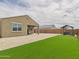 Spacious backyard with covered patio, gravel landscaping, and artificial turf area at 235 S San Gregorio Ln, Casa Grande, AZ 85194