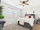 Neutral guest bedroom features a large window, ceiling fan, and platform bed with drawer storage at 235 S San Gregorio Ln, Casa Grande, AZ 85194