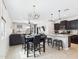 Open concept kitchen and dining area features pendant lights, black cabinets, and tile floors at 235 S San Gregorio Ln, Casa Grande, AZ 85194