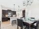 Open concept kitchen and dining area features pendant lights, black cabinets, and tile floors at 235 S San Gregorio Ln, Casa Grande, AZ 85194