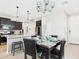 Open concept kitchen and dining area features pendant lights, black cabinets, and tile floors at 235 S San Gregorio Ln, Casa Grande, AZ 85194