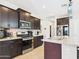 Bright kitchen with stainless steel appliances, dark cabinets, and a granite countertop island at 235 S San Gregorio Ln, Casa Grande, AZ 85194
