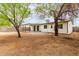 Large backyard featuring a covered patio and mature shade trees along the perimeter at 2408 W Flower St, Phoenix, AZ 85015